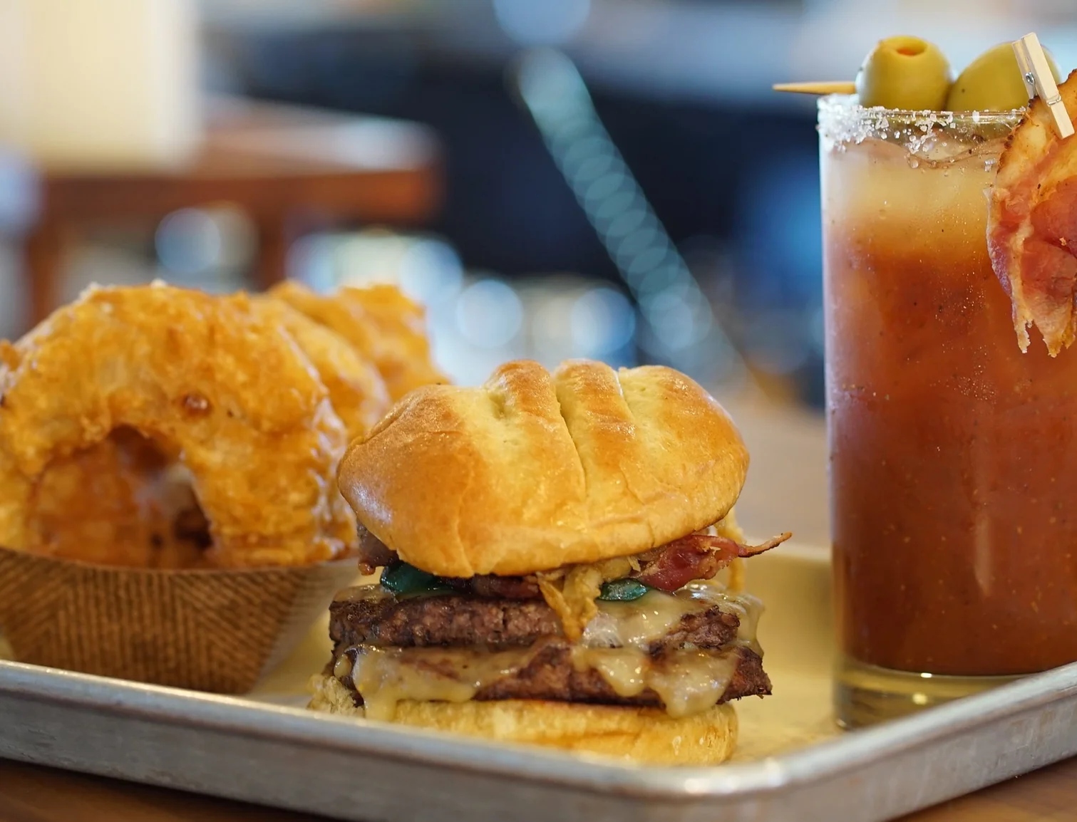 Restaurant plate of burger with chips and bloody Mary cocktail